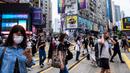 Pejalan kaki mengenakan masker sebagai tindakan pencegahan Covid-19 saat berjalan di Hong Kong (13/5/2020). Dua orang di Hong Kong dinyatakan positif Covid-19, mengakhiri perjalanan 24 hari tanpa kasus baru yang mulai melonggarkan peraturan jarak sosial. (AFP/Anthony Wallace)