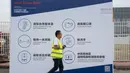 Pekerja melewati papan informasi mencegah penyebaran Covid-19 untuk peserta pameran Auto China 2020 di Beijing, Kamis (24/9/2020). Ajang Beijing International Automotive Exhibition 2020 (Auto China 2020) digelar mulai 26 September 2020 - 5 Oktober 2020 mendatang. (AP Photo/Ng Han Guan)