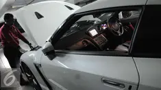 Seorang petugas sedang mengecek mobil mewah hasil sitaan tersangka kasus korupsi di Rumah Penyimpanan Benda Sitaan Negara (Rupbasan), Jakarta, Selasa (6/12). Dari puluhan mobil, terdapat mobil mewah yang harganya relatif mahal. (Liputan6.com/Helmi Afandi)