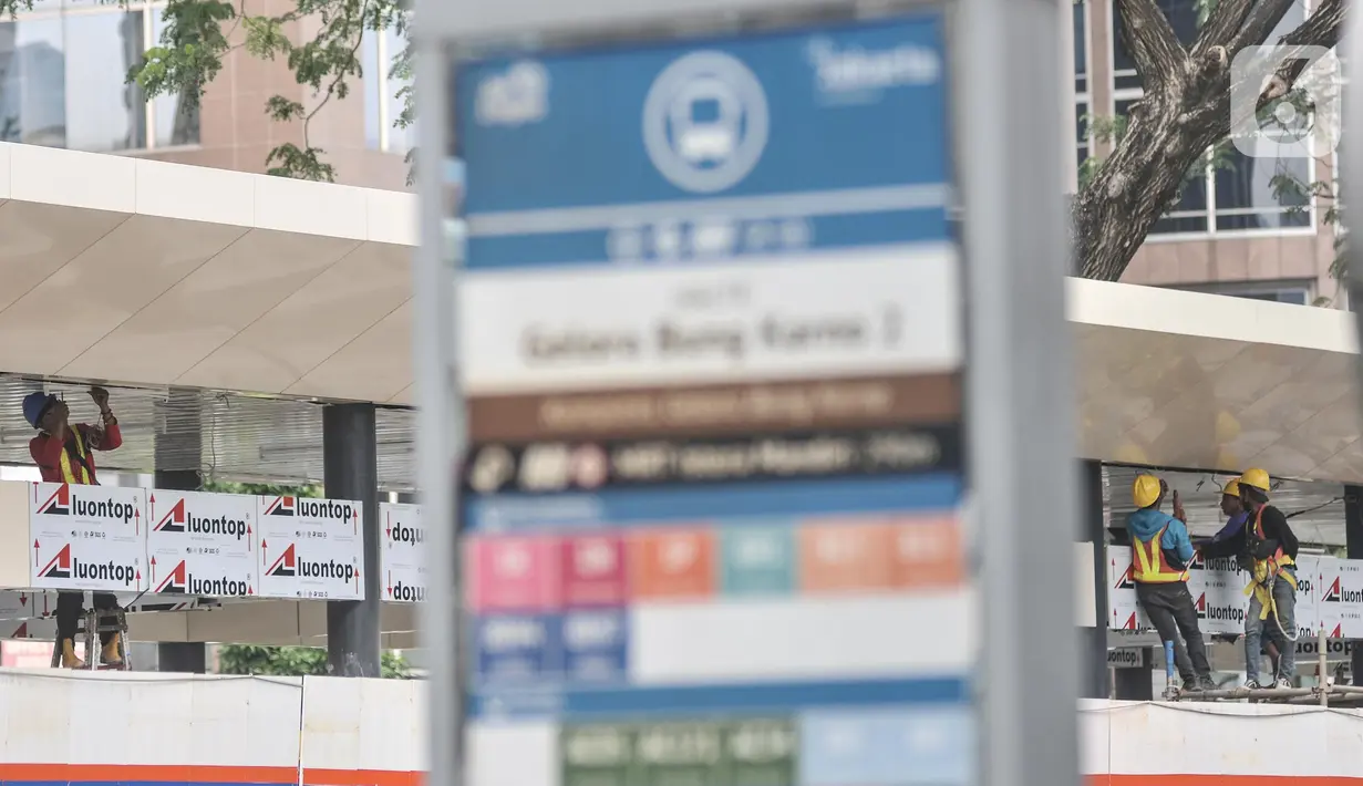 Aktivitas pekerja saat menyelesaikan proyek revitalisasi Halte Transjakarta Gelora Bung Karno (GBK), Jakarta Pusat, Senin (25/7/2022). PT TransJakarta terus mengebut proyek konstruksi revitalisasi sembilan halte yang akan berlangsung sekitar enam bulan dan akan difungsikan kembali secara bertahap sampai dengan dirampungkan secara keseluruhan pada Desember 2022. (merdeka.com/Iqbal S Nugroho)