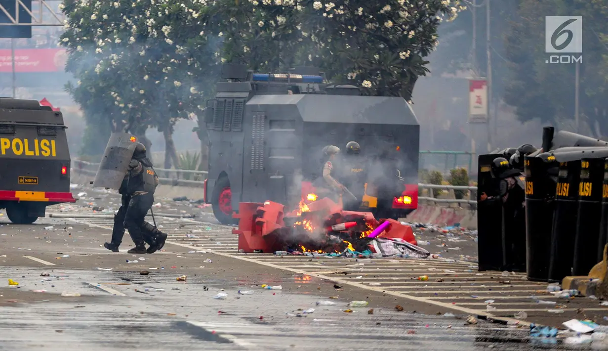 Polisi membuat barikade saat menghalau mahasiswa dalam demonstrasi menolak pengesahan RUU KUHP dan revisi UU KPK di depan Gedung DPR, Jakarta, Selasa (24/9/2019). Demonstrasi berujung ricuh saat mahasiswa berusaha masuk ke area Gedung DPR. (Liputan6.com/Faizal Fanani)