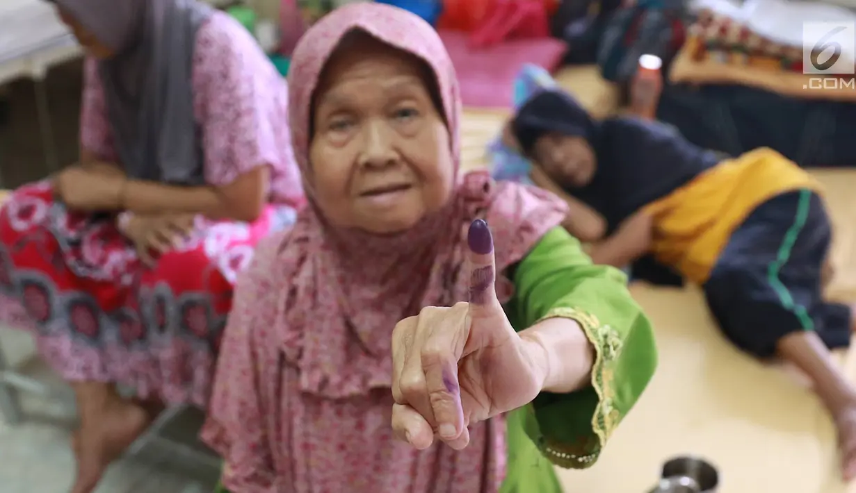 Lansia penghuni Panti Jompo Tresna Werdha Budi Mulia 1 menunjukkan jarinya yang bertinta usai mencoblos dalam Pemilu 2019 di Cipayung, Jakarta Timur, Rabu (17/4). Panitia Pemungutan Suara (PPS) melakukan pendampingan terhadap lansia yang sedang sakit. (Liputan6.com/Immanuel Antonius)
