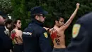 Polisi Spanyol menahan sejumlah aktivis Femen yang melakukan aksi telanjang dada memprotes penggalian makam diktator Spanyol Francisco Franco selama pertemuan tahunan di Madrid, Spanyol (24/11/2019). Aksi ini sekaligus memperingati kematian ke-44 Francisco Franco. (AFP/Oscar Del Pozo)