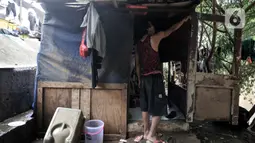 Warga bantaran menunjukkan ketinggian banjir yang merendam hingga pintu gubuk. Banjir tersebut juga menyebabkan gubuk mereka semakin rapuh dan dipenuhi sampah serta menghanyutkan barang-barang hasil pulung. (merdeka.com/Iqbal S Nugroho)