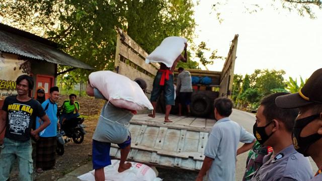 Petani Kabupaten Tuban kembali menaikan pupuk usai dihadang dan diturunkan di tengah jalan (Liputan6.com/Ahmad Adirin)