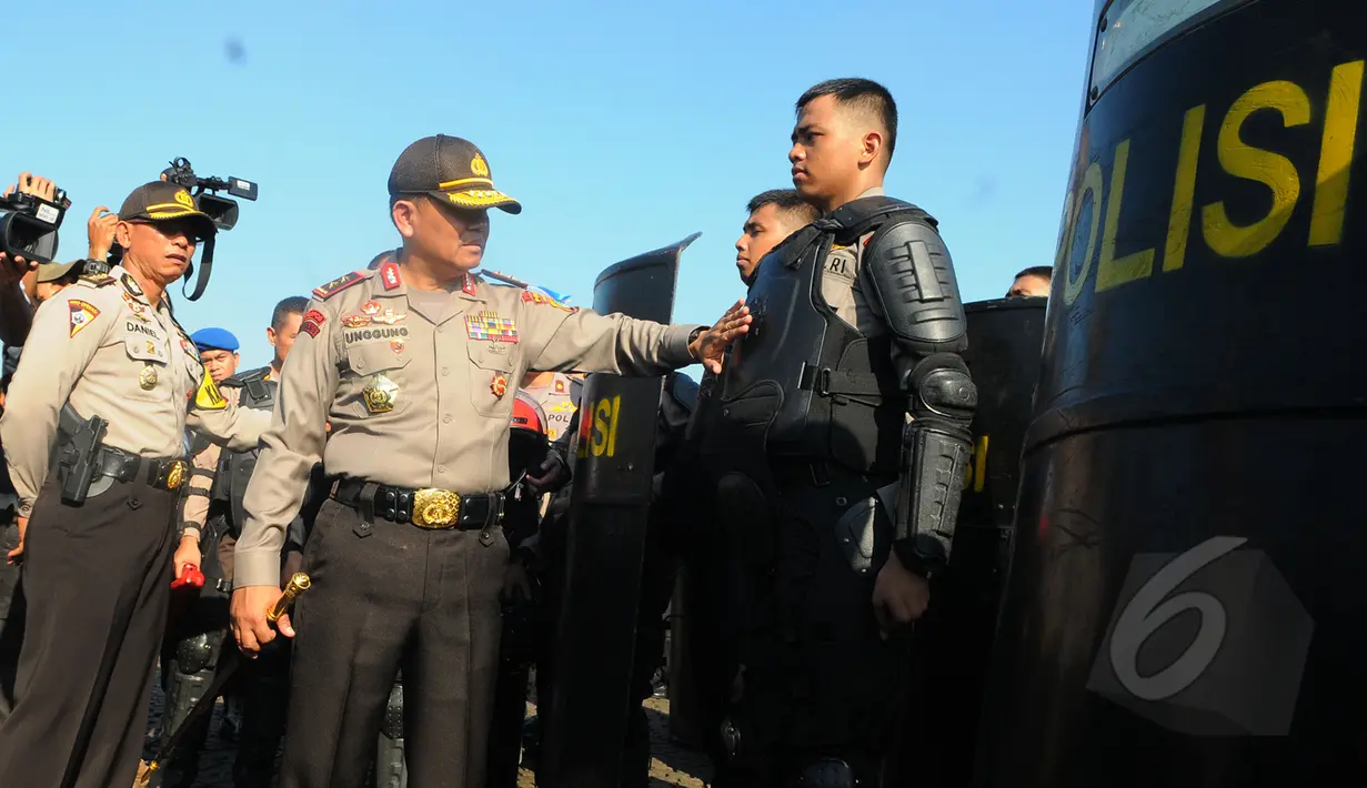 Irjen Unggung Cahyono (tengah) memeriksa kesiapan anggotanya pada apel gelar pasukan di Kawasan Monas, Jakarta,  Rabu (8/4/2015). Polda Metro Jaya menerjunkan 4.236 personel untuk mengamankan Peringatan KAA. (Liputan6.com/Herman Zakharia)