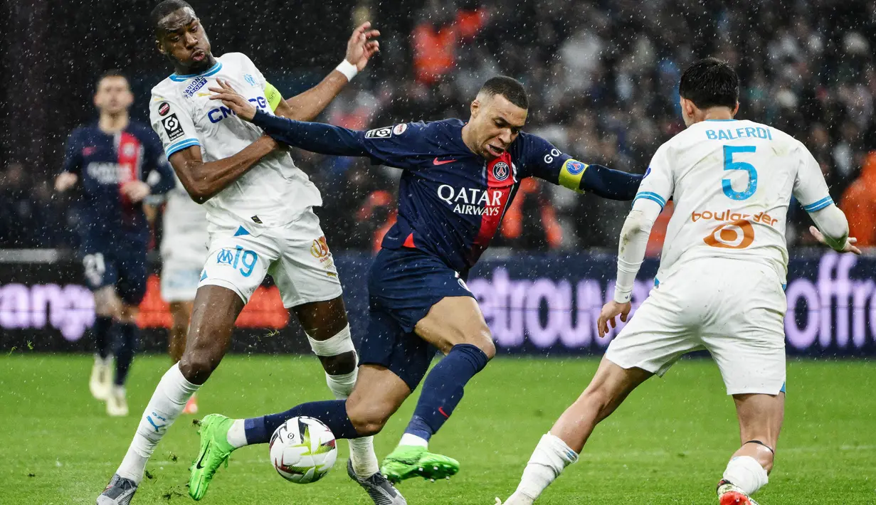Pemain Paris Saint-Germain, Kylian Mbappe, berebut bola dengan pemain Marseille, Geoffrey Kondogbia, dalam duel pekan ke-27 Ligue 1 2023/2024 di Stade Velodrome, Senin (1/4/2024). PSG menang dengan skor 2-0. (AFP/Christophe Simon)