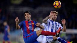 Striker Barcelona, Luis Suarez, berebut bola dengan pemain Real Sociedad, Inigo Martinez, pada pekan ke-13 La Liga Spanyol di Estadio Municipal de Anoeta, Minggu (27/11/2016). (Reuters/Vincent West)