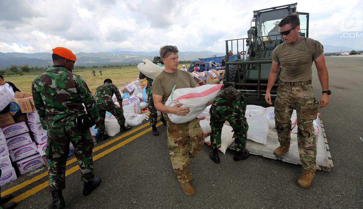 Tentara Amerika Serikat mendistribusikan bantuan logistik yang tiba di Bandara Mutiara Sis Al-Jufri, Palu, Sulawesi Tengah, Minggu (7/10). Tentara AS membantu mendistribusikan dari landasan menuju bandara. (Liputan6.com/Fery Pradolo)