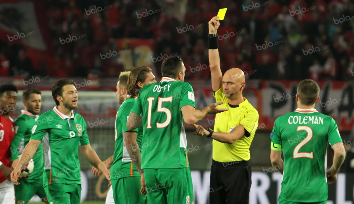 Wasit asal Rusia, Sergei Karasev, mengganjar bek Irlandia, Shane Duffy, karena pelanggaran keras terhadap striker Austria, Marc Janko. (Bola.com/Reza Khomaini)