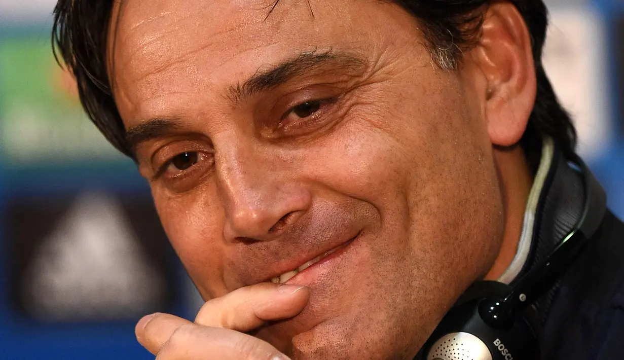 Pelatih Sevilla, Vincenzo Montella tersenyum saat konferensi pers di stadion Old Trafford di Manchester, Inggris (12/3). Sevilla akan melawan Manchester United pada leg kedua babak 16 besar Liga Champions. (AFP Photo/Oli Scarff)