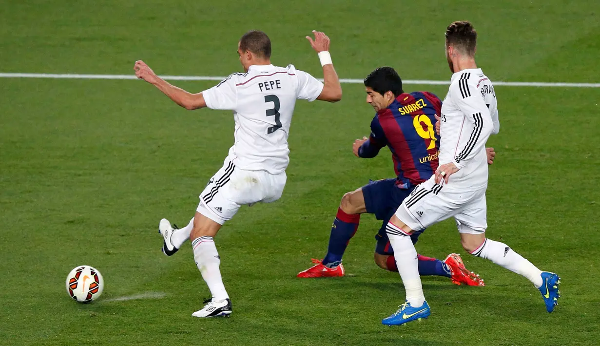 Penyerang Barcelona, Luis Suarez berusaha melewati dua pemain Real Madrid pada laga Liga Spanyol di Stadion Nou Camp, Senin (23/3/2015). Barcelona Menang 2-1 atas Real Madrid. (Reuters/Gustau Nacarino)