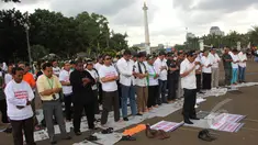 Massa dari Aliansi TKI Menggugat melakukan aksi unjuk rasa dengan cara salat di depan Istana Negara, Jakarta, Selasa (7/4/2015). Mereka menuntut Presiden Jokowi mencabut moratorium larangan pengiriman TKI ke Timur Tengah. (Liputan6.com/Helmi Afandi)
