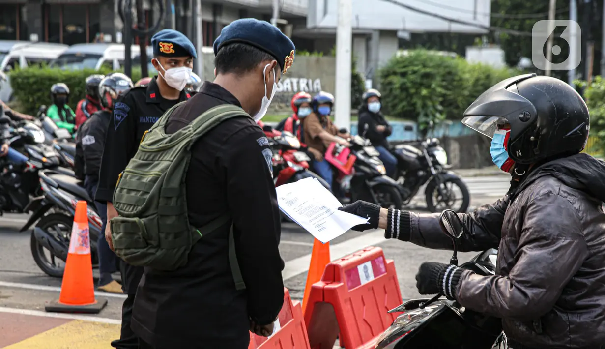 Petugas polisi mengecek dokumen pengendara saat penyekatan ruas Jalan Simatupang mengarah ke Fatmawati, Jakarta, Sabtu (10/7/2021). Penambahan titik penyekatan jalan untuk mempertegas bahwa Jakarta masih masa PPKM Darurat. (Liputan6.com/Faizal Fanani)