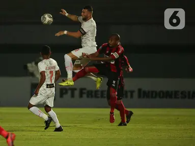 Pemain Persija Jakarta, Marko SImic (tengah) berebut bola diudara dengan pemain Persipura Jayapura, Ian Luois Kabes dalam pertandingan BRI Liga 1 2021/2022 di Stadion Indomilk Arena, Kabupaten Tangerang, Minggu (19/9/2021). Persija Jakarta harus puas bermain tanpa gol. (Bola.com/Ikhwan Yanuar)