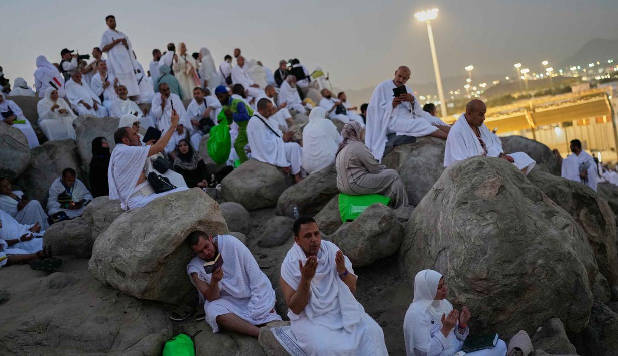 Umat Muslim berdoa di puncak bukit berbatu yang dikenal sebagai Jabal Rahmah atau Gunung Rahmat, di Dataran Arafah, selama ibadah haji tahunan di dekat kota suci Mekah, Arab Saudi, Selasa 26 Mei 2026. (AP Photo/Altaf Qadri)