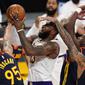 Bintang Los Angeles Lakers, LeBron James, saat berusaha menembak bola di tengah kepungan pemain Golden State Warriors, Senin (1/3/2021) pagi WIB. (AP Photo/Mark J. Terrill)