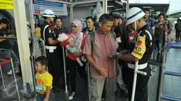 Petugas memeriksa tiket calon penumpang kereta api di Stasiun Pasar Senen, Jakarta, Jumat (14/4). Pada libur Paskah dan akhir pekan pengguna jasa kereta api di Daop 1 Jakarta mengalami peningkatan menjadi 33.000 penumpang. (Liputan6.com/Helmi Afandi)