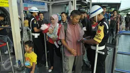Petugas memeriksa tiket calon penumpang kereta api di Stasiun Pasar Senen, Jakarta, Jumat (14/4). Pada libur Paskah dan akhir pekan pengguna jasa kereta api di Daop 1 Jakarta mengalami peningkatan menjadi 33.000 penumpang. (Liputan6.com/Helmi Afandi)