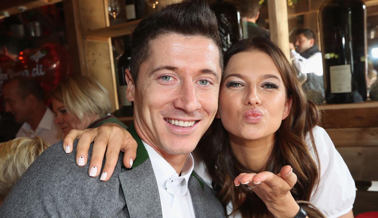 Muncul berbagai spekulasi bahwa sang istri, Anna tidak ingin pergi ke Paris. Namun, striker Polandia itu menolak desas-desus bahwa Anna menentang kepindahannya ke PSG. (AFP/Alexandra Beier)