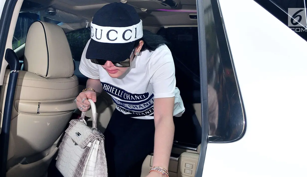 Penyanyi Syahrini turun dari mobil saat mendatangi Bareskrim Mabes Polri untuk menjalani pemeriksaan terkait kasus First Travel, Jakarta, Rabu (27/9). (Liputan6.com/Helmi Afandi)