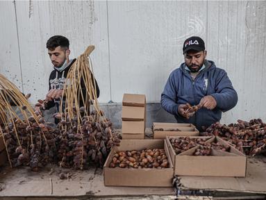 Pekerja Palestina menyortir dan mengemas kurma di sebuah pabrik sebagai persiapan untuk puasa Ramadhan di Khan Yunis di Jalur Gaza selatan pada 19 Maret 2023. (AFP/Said Khatib)