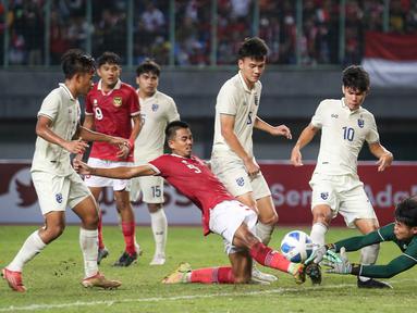 Pemain Timnas Indonesia U-19, Kakang Rudianto berusaha memasukan bola ke gawang Thailand yang dijaga Narongsak Naengwongsa dalam pertandingan babak penyisihan Grup A Piala AFF U-19 yang berlangsung di Stadion Patriot Candrabhaga, Bekasi, Rabu (6/7/2022). (Bola.com/Bagaskara Lazuardi)