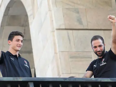 Pemain baru AC Milan, Gonzalo Higuain (kanan) dan Mattia Caldara menyapa suporter dari balkon di alun-alun pusat Milan Piazza Duomo (3/8). Higuain dan Caldara didapatkan Milan dari Juventus. (AFP Photo)