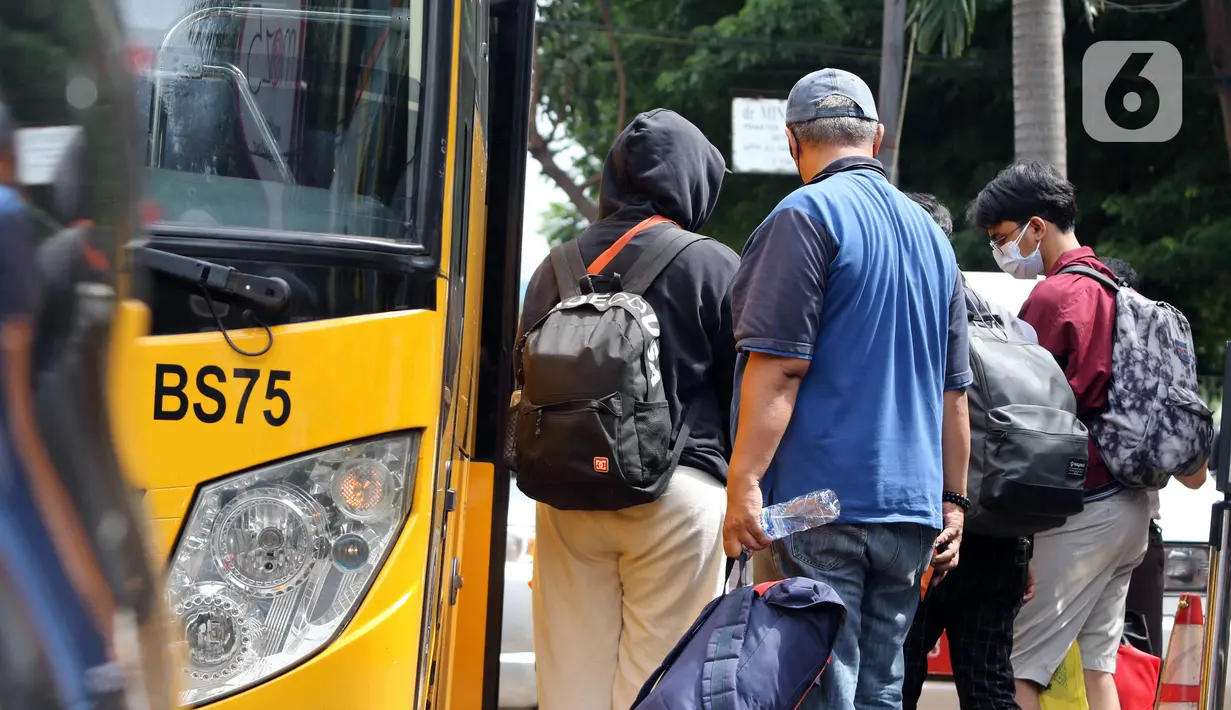 Sejumlah pasien COVID-19 masuk ke dalam bus sekolah yang akan mengantarkan mereka menuju RSDC Wisma Atlet di Puskesmas Kecamatan Tebet, Jakarta, Kamis (3/2/2022). Satgas Penanganan COVID-19 mencatat kenaikan kasus positif COVID-19 dalam satu pekan terakhir. (Liputan6.com/Herman Zakharia)