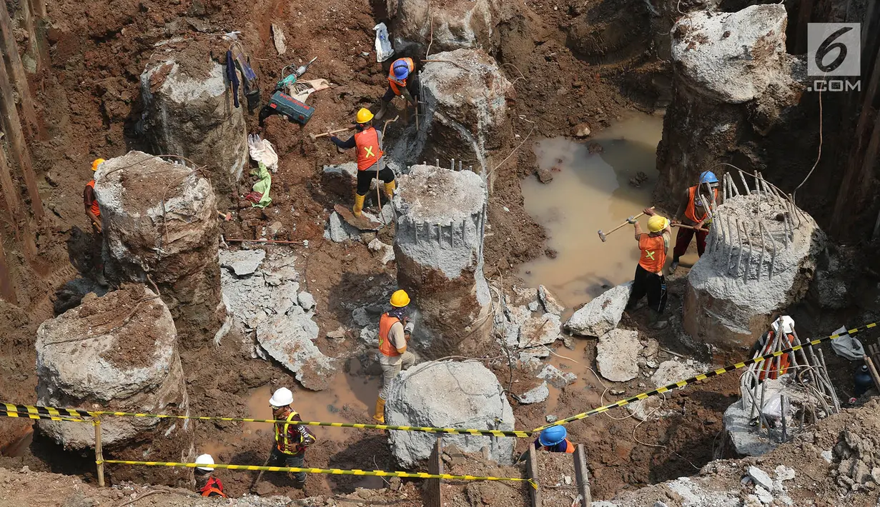 Pekerja membongkar beton untuk pengerjaan proyek LRT Jabodetabek di kawasan Cawang, Jakarta Timur, Selasa (22/8). (Liputan6.com/Immanuel Antonius)