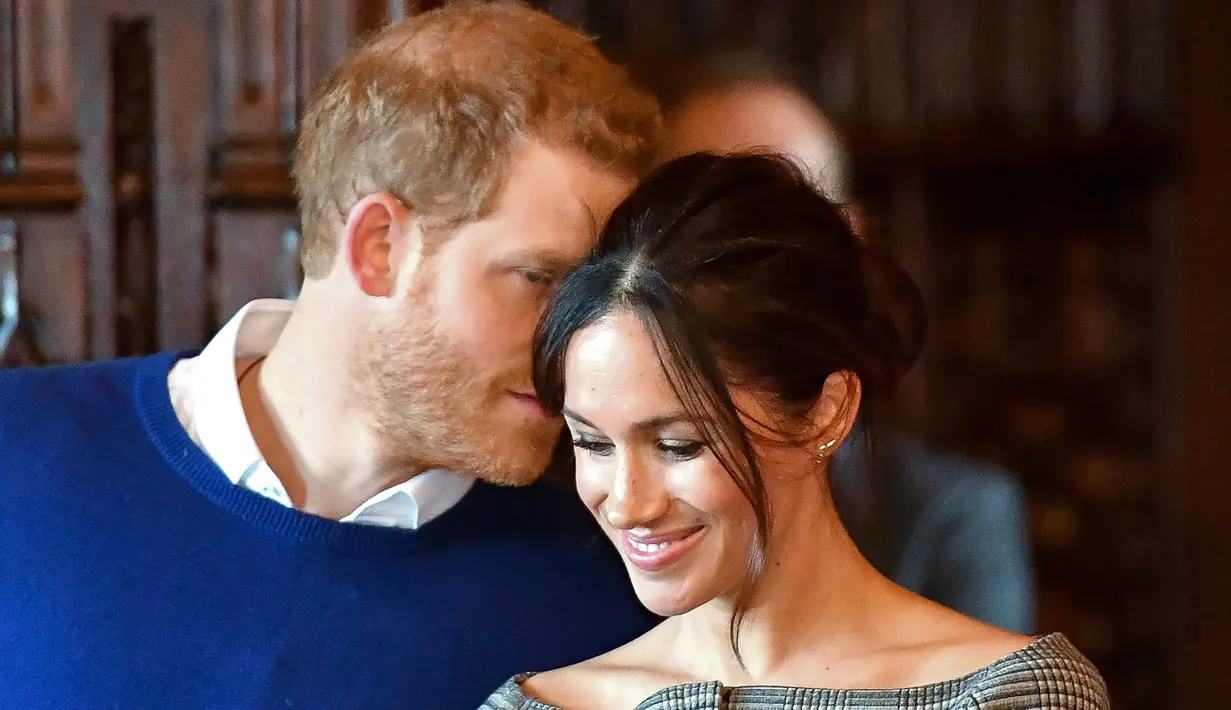 Pangeran Harry terlihat membisikkan sesuatu kepada sang tunangan, Meghan Markle ketika keduanya menjalani kunjungan ke Cardiff Castle, Wales, Kamis (18/1). Entah apa yang dibisikkan, namun momen manis itu membuat Meghan tertawa. (BEN BIRCHALL/POOL/AFP)