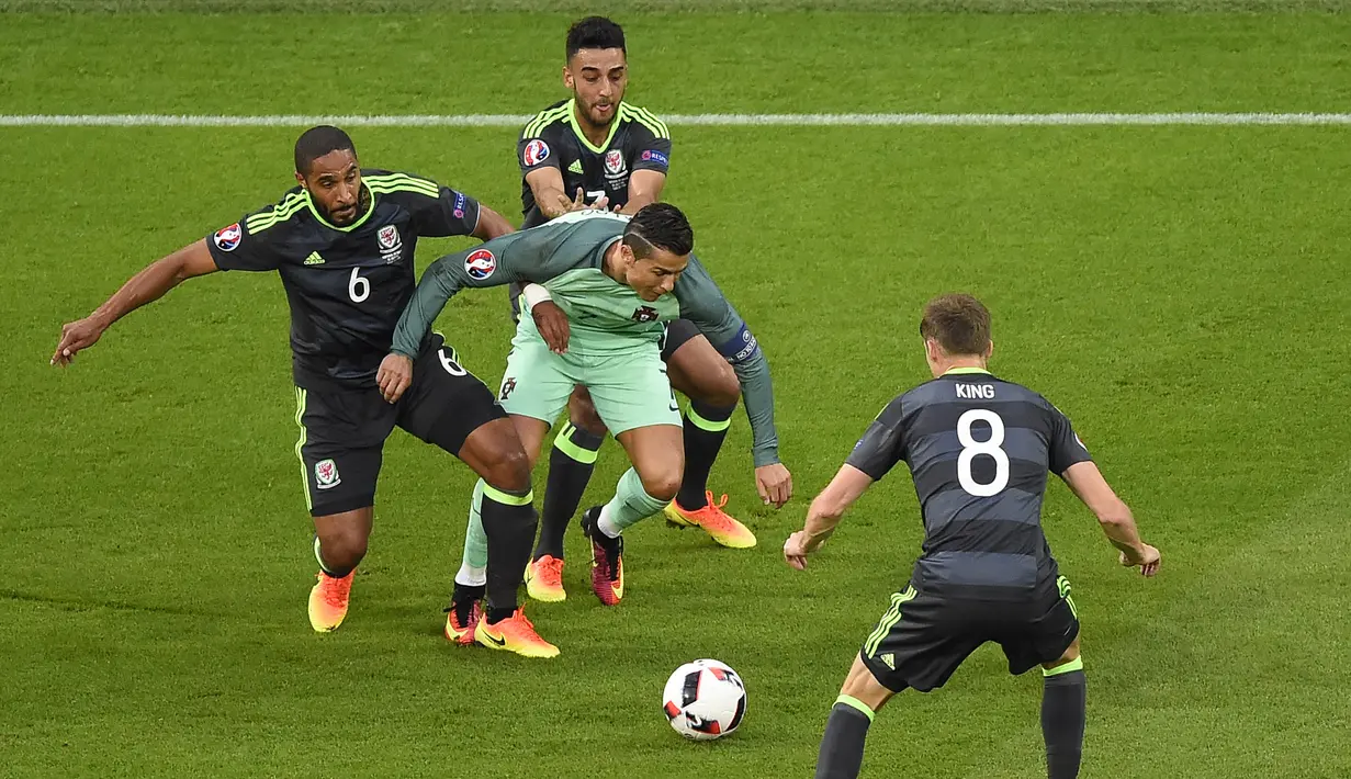 Cristiano Ronaldo saat berusaha melewati pemain Wales dalam pertandingan semifinal Euro 2016 antara Portugal melawan Wales di stadion Parc Olympique Lyonnais pada 6 Juli 2016. (AFP/Romain Lafabregue)