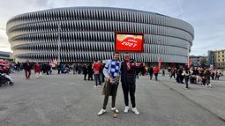 Dua fans dari Real Sociedad dan Athletic Bilbao berpose di halaman Stadion San Mames, Bilbao, Spanyol menjelang laga lanjutan Liga Spanyol 2023/2024 antara Athletic Bilbao dan Real Sociedad, 13 Januari 2024. (Bola.com/Yus Mei Sawitri)