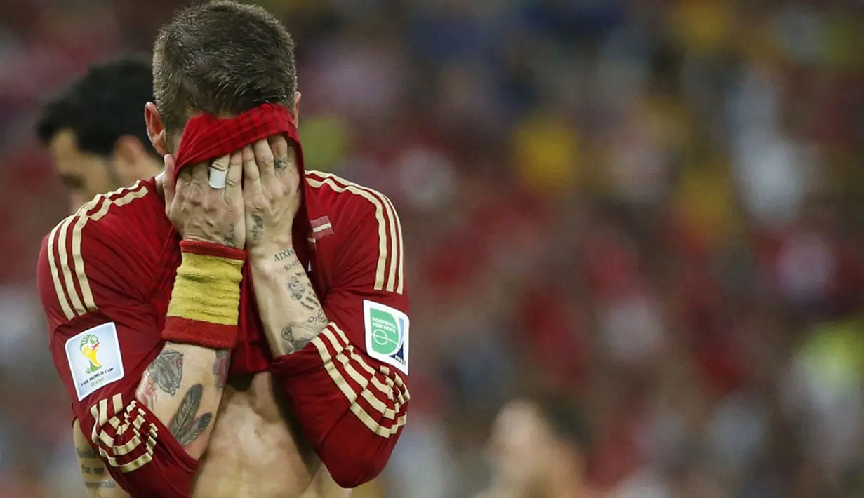 Pemain belakang Spanyol, Sergio Ramos, menutupi wajahnya usai dikalahkan Chile 0-2 di Stadion Maracana, Rio de Janeiro, Brasil, (19/6/2014). (REUTERS/Jorge Silva)