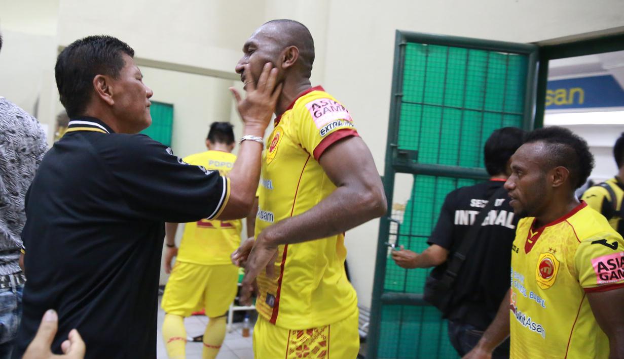 Pelatih Beny Dollo menyapa Patrich Wanggai saat Tim Sriwijaya FC merayakan kemenangan diloker room usai mengalahkan Arema Cronus di Stadion Manahan, Solo, Minggu (11/10/2015). (Bola.com/NIcklas Hanoatubun)