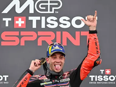 Pembalap MotoGP asal Italia dari tim Aprilia Racing, Marco Bezzecchi merayakan kemenangannya di podium setelah memenangkan Sprint Race pada MotoGP Grand Prix Indonesia di Sirkuit Internasional Mandalika, Nusa Tenggara Barat, pada Sabtu 4 Oktober 2025. (SONNY TUMBELAKA/AFP)