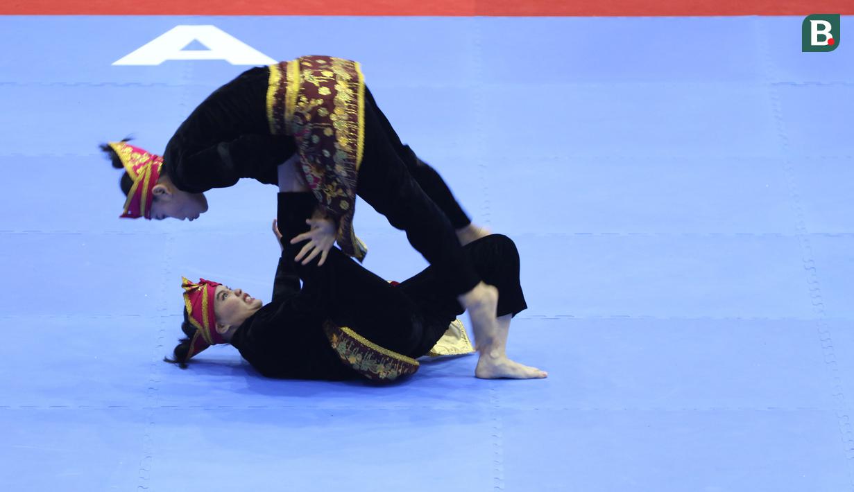 Pesilat Indonesia Riska Hermawan (bawah) dan Ririn Rinasih saat bertanding dalam nomor Seni Ganda Wanita Pencak Silat Sea Games 2021 Vietnam di Bac tu Liem Sport Center, Hanoi, Rabu (11/5/2022). (Bola.com/Ikhwan Yanuar)
