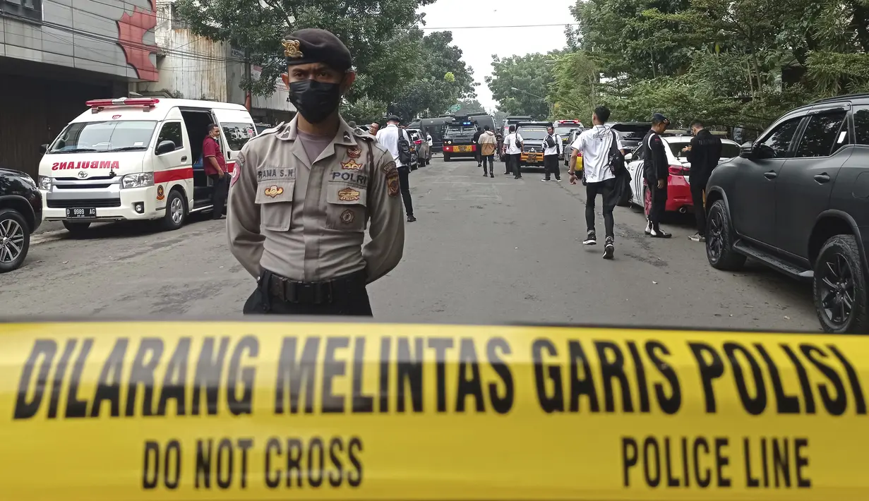 Seorang petugas polisi berjaga di jalan menuju  insiden ledakan yang terjadi Polsek Astana Anyar, Bandung, Jawa Barat, Rabu (7/12/2022). Polri menyatakan ledakan yang terjadi pagi ini sekitar pukul 08.15 WIB di Polsek Astana Anyar Kota Bandung diduga merupakan aksi bom bunuh diri. (AP Photo/Ahmad Fauzan)