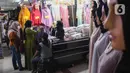 Calon pembeli memilih baju di Pasar Tanah Abang, Jakarta, (28/3/2022). Sepekan menjalang bulan suci Ramadan, Pasar Tanah Abang mulai dipadati pembeli yang hendak berbelanja untuk kebutuhan bulan puasa. (Liputan6.com/Herman Zakharia)