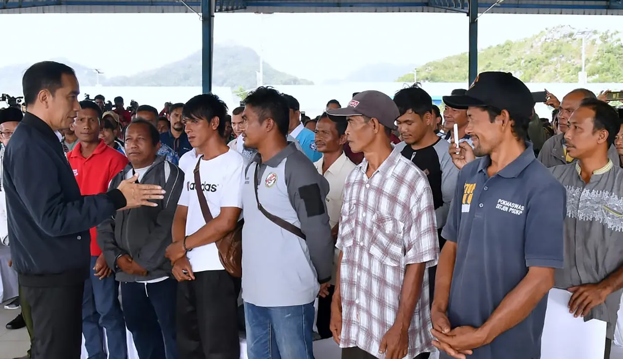 Presiden Joko Widodo (kiri) berbincang dengan nelayan Natuna saat melakukan kunjungan kerja di Sentra Kelautan Perikanan Terpadu (SKPT), Natuna, Kepulauan Riau, Rabu (8/1/2020). Kunjungan Jokowi tersebut pascakapal coast guard milik China berlayar di perainan laut Natuna (HO/PRESIDENTIAL PALACE/AFP)