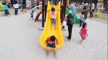 Anak-anak bermain seluncur di Lapangan Banteng, Jakarta, Minggu (14/10). Lapangan Banteng semakin ramai dikunjungi pada hari Minggu. (Liputan6.com/JohanTallo)