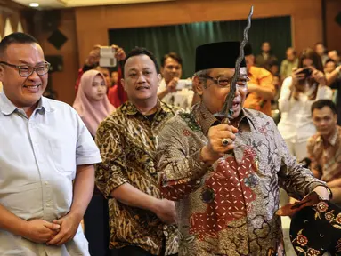 Ketua Umum PBNU KH Said Aqil Siroj menunjukan keris  dalam acara Silaturrahim Kebudayaan di Gedung PBNU, Jakarta (28/7). Tema acara tersebut Meneguhkan Kebudayaan Bangsa, Memperkuat Keutuhan Negara Kesatuan RI. (Liputan6.com/Faizal Fanani)