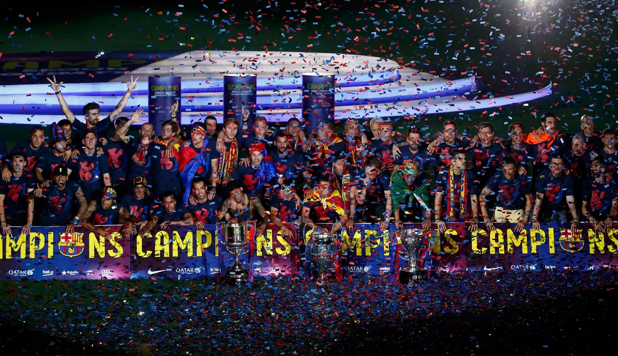 Pemain Barcelona dan anggota staf berpose dengan piala saat parade kemenangan di stadion Camp Nou, Spanyol (7/6/2015). Barcelona untuk kelima kalinya meraih piala liga Champions usai mengalahkan Juventus 3-1 di Stadion Olympic. (REUTERS/Gustau Nacarino)