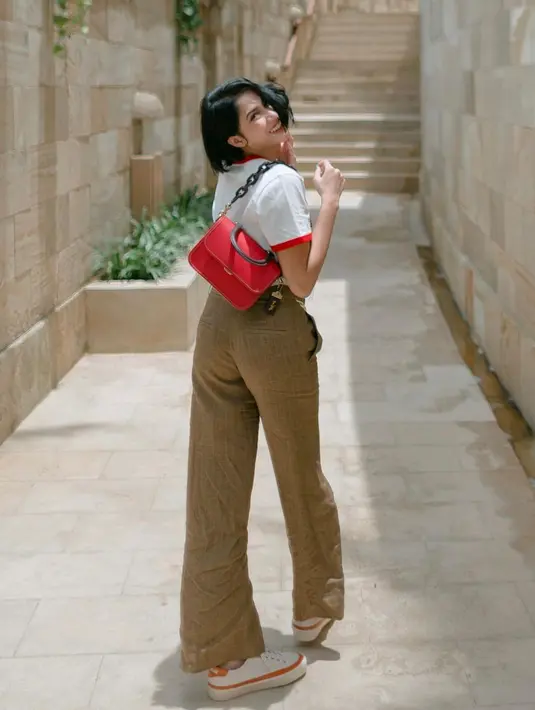 <p>Peralihan gaya boyish yang trendi dengan kaus+celana lebar+sneaker dan tas bahu (Foto: Instagram @aghninyhaque)</p>