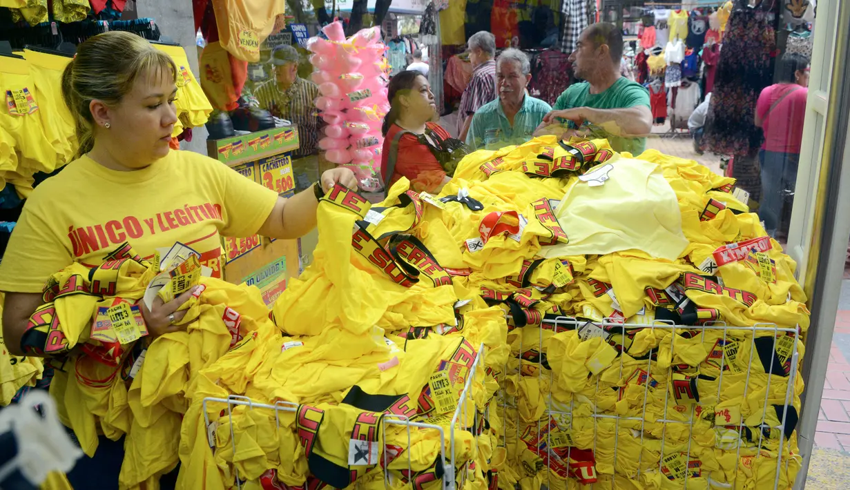 Pramuniaga menata pakaian dalam berwarna kuning yang dijajakan di sebuah toko di Medellin, Kolombia, Kamis (29/12). Sejumlah warga Kolombia berburu pakaian dalam berwarna kuning untuk dipakai saat perayaan tahun baru. (AFP PHOTO/Camilo GIL)