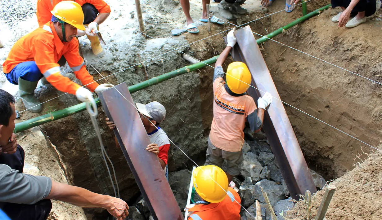 Para pekerja melakukan pemasangan pondasi "Jembatan Asa SCTV" di desa Jayasari, Kecamatan Cimarga, Kabupaten Lebak Banten, Minggu (3/5/2015). Program kemanusiaan tersebut dalam rangka memperingati ulang tahun SCTV yang ke-25. (Dok. SCTV)