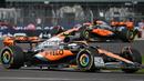 Pembalap McLaren, Lando Norris dan Oscar Piastri memacu mobilnya saat balapan Formula 1 GP Inggris di Sirkuit Silverstone, Inggris, 9 Juli 2023. (AFP/Andrej Isakovic)