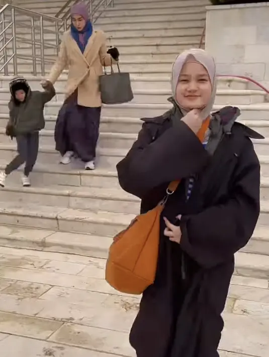 Seperti sang ibunda Fenita Arie, Kayla Aeeshya juga ikut mengubah penampilan dengan berhijab. Anak Arie Untung ini tampil stylish saat liburan mengenakan coat hitam dengan kerudungnya. Credit: (@fenitarie)