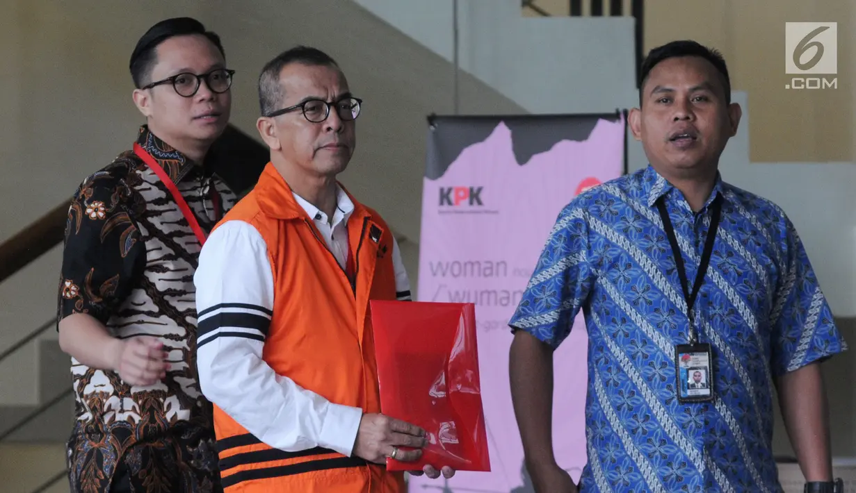 Mantan Dirut PT Garuda Indonesia Emirsyah Satar (tengah) menutupi borgol di tangannya dengan map merah saat akan menjalani pemeriksaan di Gedung KPK, Jakarta, Jumat (16/8/2019). Ini merupakan pemeriksaan perdana Satar pascaditahan oleh penyidik KPK. (merdeka.com/Dwi Narwoko)