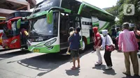 Sejumlah calon penumpang bersiap menaiki bus di Terminal Kampung Rambutan Jakarta, Kamis (24/3/2022). Pemerintah memastikan bahwa masyarakat diperbolehkan mudik Lebaran tahun 2022 dengan syarat sudah mendapatkan vaksin dosis lengkap dan ketiga atau booster. (Liputan6.com/Herman Zakharia)